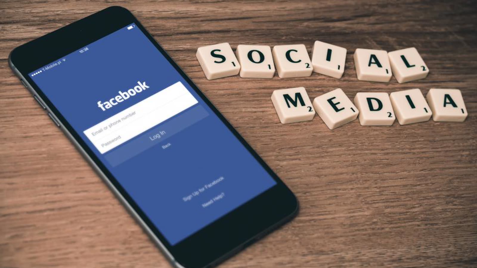 Un móvil con la pantalla de inicio de sesión de Facebook junto a fichas de «social media» (imagen de archivo)