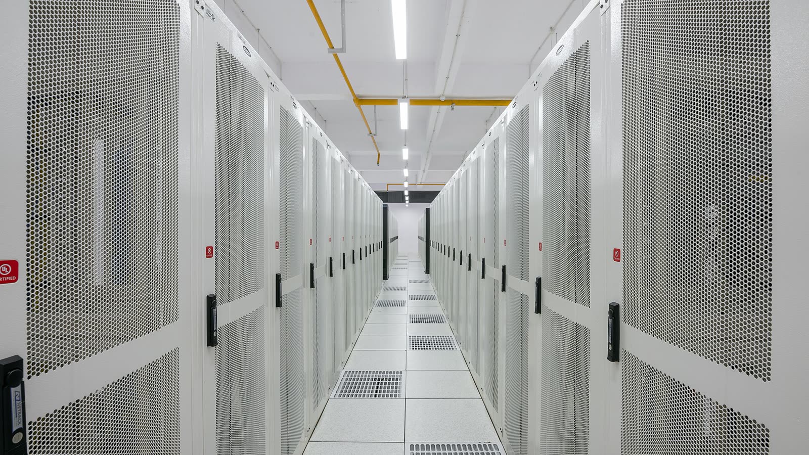 Pasillo de un centro de datos con armarios de servidores blancos (imagen de archivo)